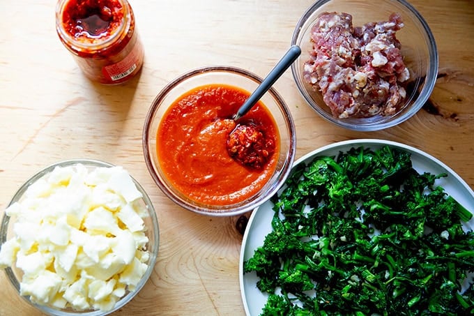 Topping ingredients for a grandma-style pizza on a countertop.