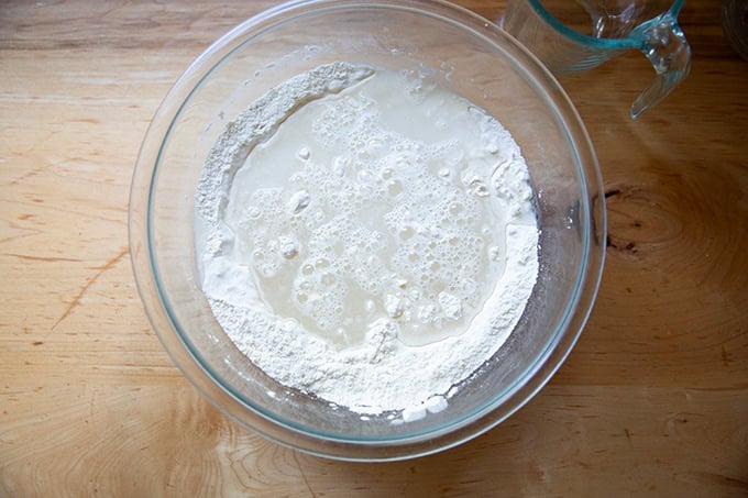 Water added to a bowl filled with the dry ingredients for focaccia.