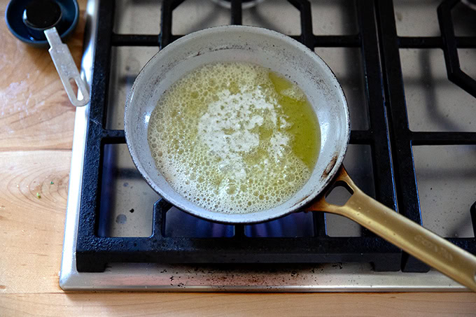 A small skillet filled with melted butter and olive oil.