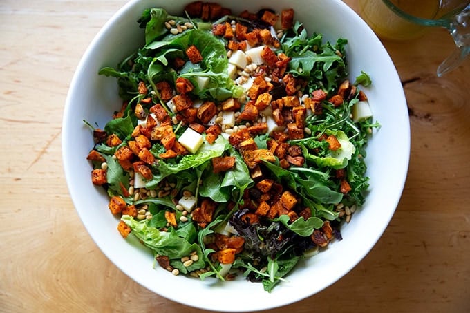 A roasted sweet potato salad with gruyere and toasted pine nuts, untossed.