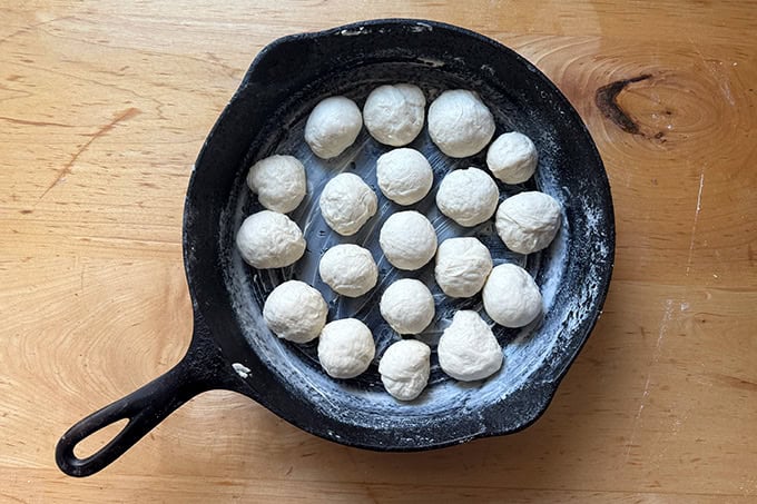 Monkey bread dough balls in a cast iron skillet.
