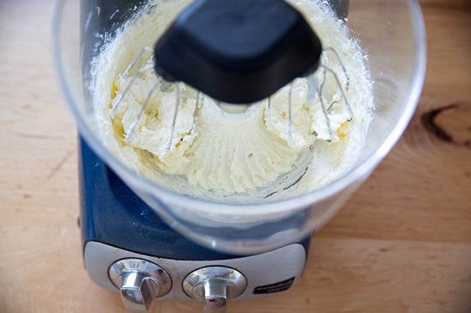 A stand mixer beating together sugar and cream cheese.