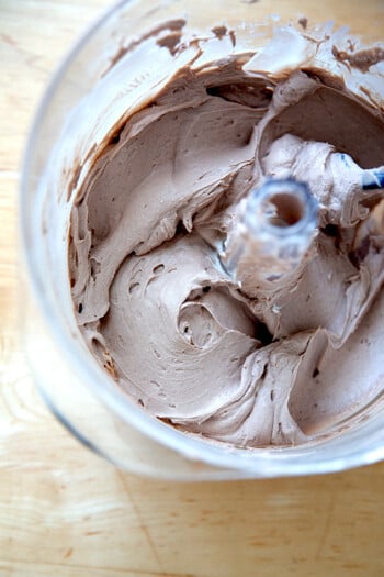 A stand mixer holding whipped chocolate cream cheese frosting.