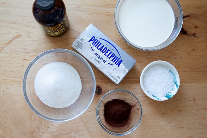 The ingredients to make chocolate whipped cream cheese frosting.