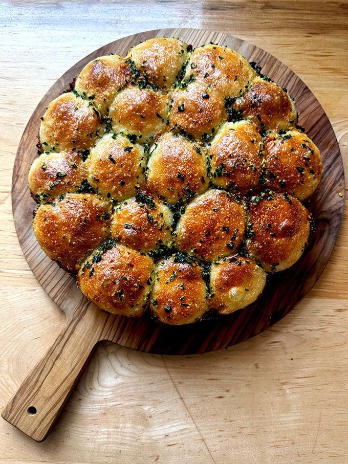 Just baked garlic-herb monkey bread on a cutting board.