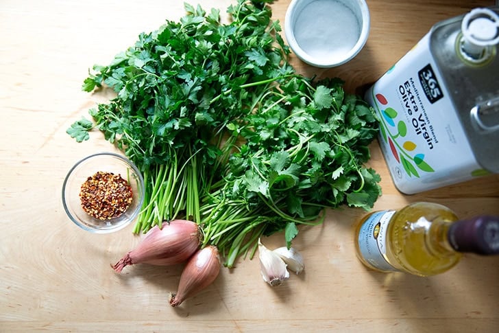The ingredients to make chimichurri on a counter top.