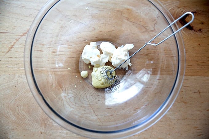 Three tablespoons of mayonnaise and one tablespoon of mustard in a large bowl.