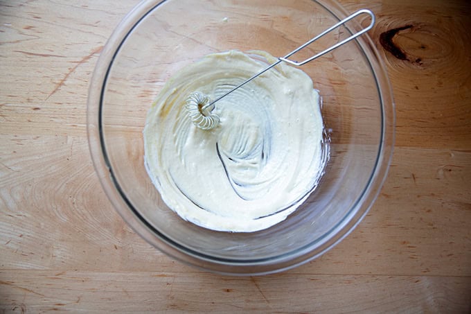 A mayonnaise-mustard mixture stirred together in a large bow.